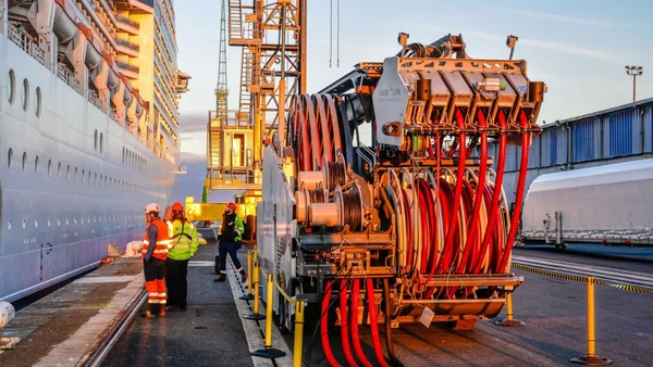 Installation de branchement électrique à quai pour un paquebot, avec des ouvriers en sécurité.