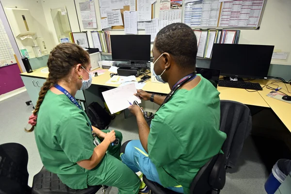 Des soignants examinent des documents dans un service hospitalier.