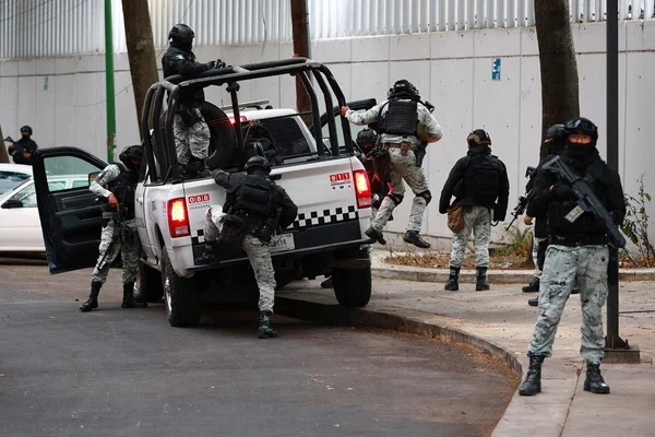 Des policiers tactiques mexicains embarquent dans un véhicule d'intervention marqué '911'.