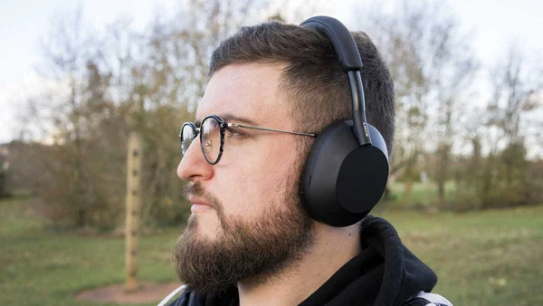 Utilisateur du Sony WH-1000XM6 en extérieur, casque à réduction de bruit active.