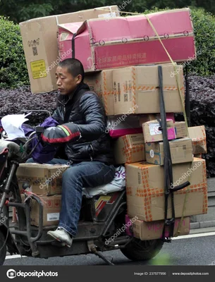 Livreur chinois sur un triporteur chargé de colis, illustrant le métier de livreur.