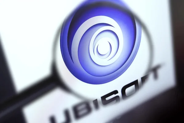 Logo d'Ubisoft sur écran avec une loupe agrandissant le motif central.