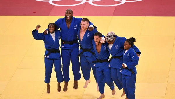 L'équipe de France de judo célébrant en sautant sur le tapis.