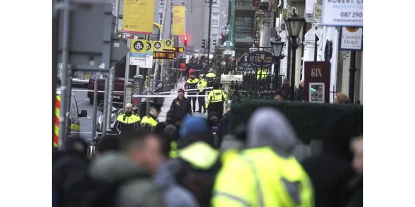 Périmètre de sécurité à Dublin avec gardas et badauds.