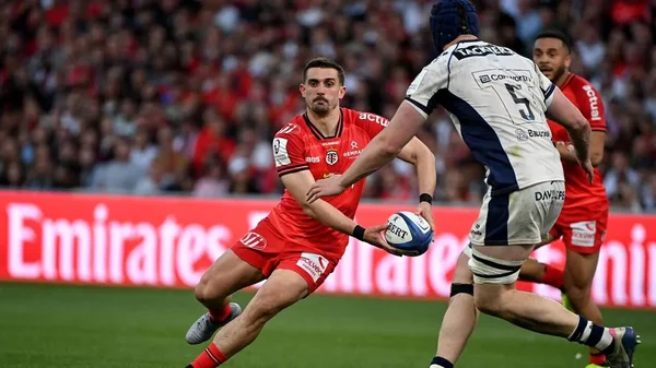 Action de rugby avec un joueur du Stade Toulousain en maillot rouge.