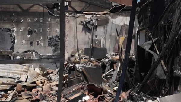 Intérieur d'un logement sinistré après un incendie à Marseille, montrant des murs calcinés et des débris au sol.