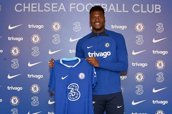 Un représentant de Chelsea présentant un maillot du club lors d'une annonce.