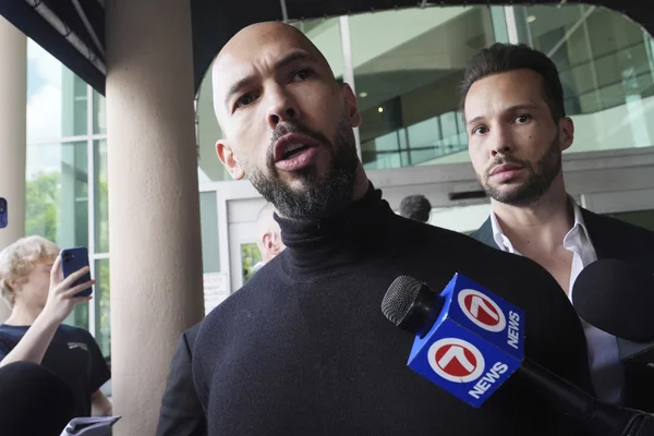 Andrew Tate s'adressant à la presse après son départ de Roumanie.