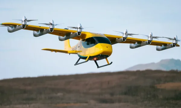 Le taxi aérien autonome Wisk Aero en vol au-dessus de collines au coucher du soleil.
