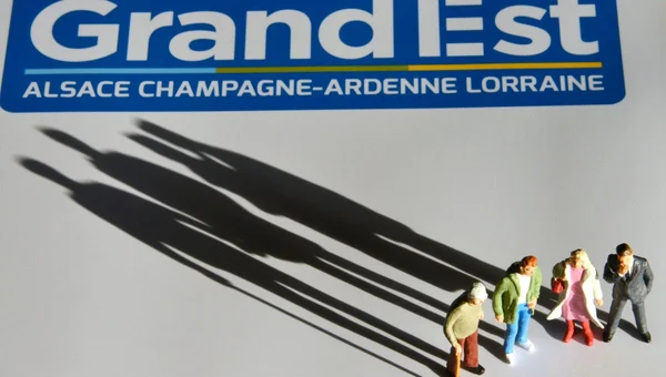 Figurines symbolisant le dialogue interreligieux devant le logo du Grand Est.