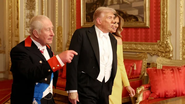 Le roi Charles III s'adressant à Donald Trump lors de la visite d'État à Windsor, avec Melania Trump en arrière-plan.