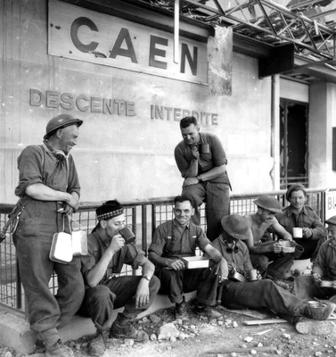 Soldats alliés devant la gare de Caen en 1944, après les combats.