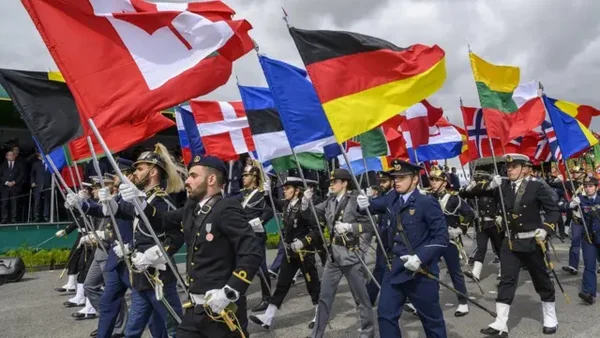 Défilé militaire avec des drapeaux de pays membres de l'OTAN.