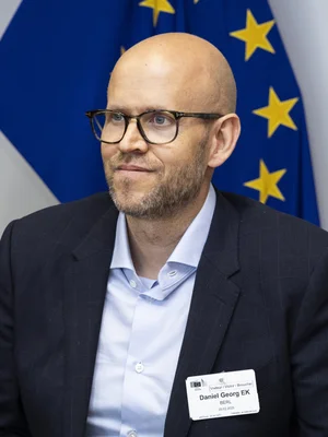 Daniel Ek, cofondateur de Neko Health, photographié devant un drapeau européen lors d'une visite officielle.