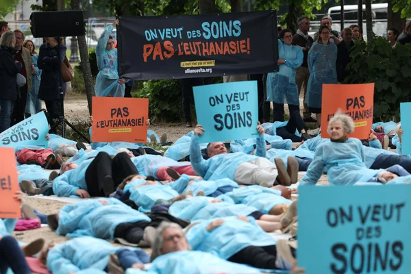 Manifestants en blouses médicales lors d'un die-in contre la loi sur l'aide à mourir, à Paris.