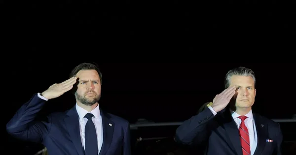 J.D. Vance (à gauche) et un autre officiel saluant lors d'une cérémonie.