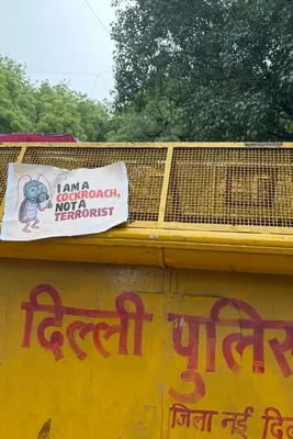 Une barricade de la police de Delhi avec une pancarte proclamant « Je suis un cafard, pas un terroriste ».