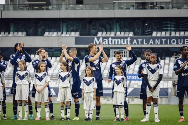 Joueurs des Girondins de Bordeaux et enfants applaudissant les supporters au Matmut Atlantique.