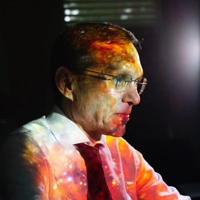 Le professeur Avi Loeb, chasseur d'aliens, avec une projection céleste sur le visage.