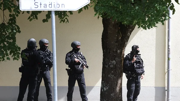 Des policiers en tenue d'intervention devant un panneau 'Stadion' après l'attaque dans un établissement scolaire bavarois.