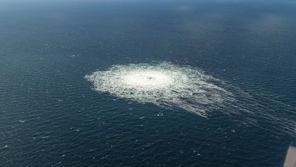 Photographie aérienne d'une zone d'eau turbulente due à une fuite de gaz sous-marine.