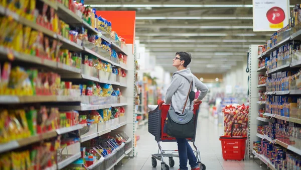 Un client fait ses courses dans un supermarché, illustrant l'accès à une alimentation saine.