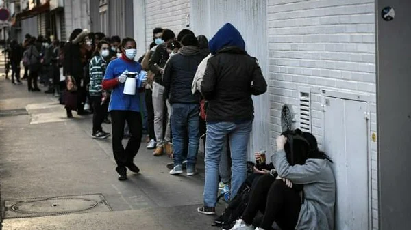 File d'attente de personnes précaires, dont des étudiants, dans une rue de France en 2024, symbole de la montée de la pauvreté.