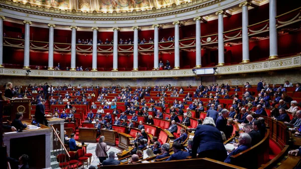 Séance solennelle au Parlement français : un orateur à la tribune devant les députés dans l'hémicycle.