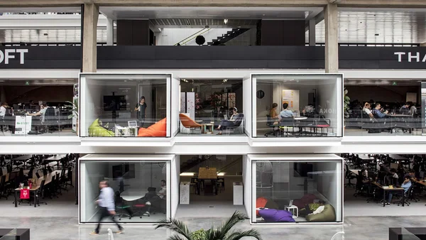 Les modules de travail vitrés suspendus de Station F, véritables bulles de collaboration pour les startups.