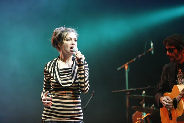 Catherine Ringer et un guitariste des Rita Mitsouko en concert, sous un éclairage bleu.