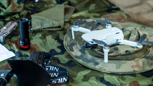 Drone quadricoptère blanc sur un chapeau de camouflage, symbolisant une frappe de drone ayant éliminé un cadre du Front Polisario.