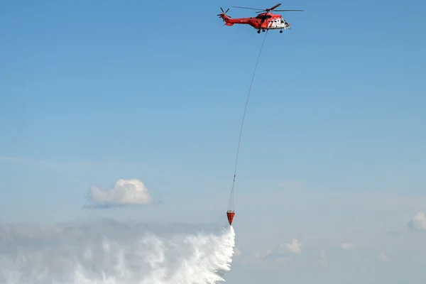 Un hélicoptère bombardier d'eau en action lors d'un entraînement des pompiers.