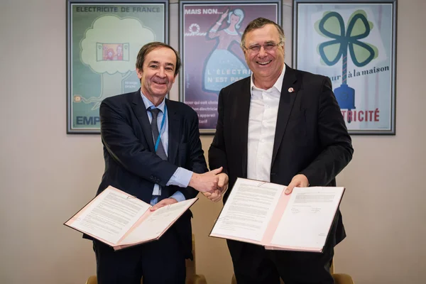 Poignée de main entre deux cadres dirigeants d'EDF et TotalEnergies lors de la signature du contrat.