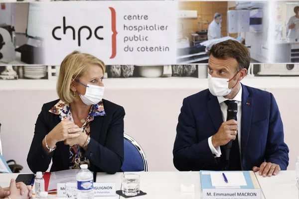 Emmanuel Macron en visite au centre hospitalier du Cotentin, masqué, lors d'une réunion.