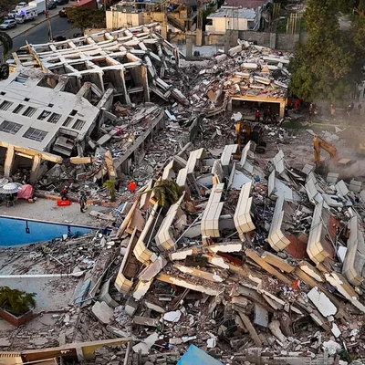 Vue aérienne des ruines d'un immeuble effondré montrant l'ampleur des destructions après le séisme.