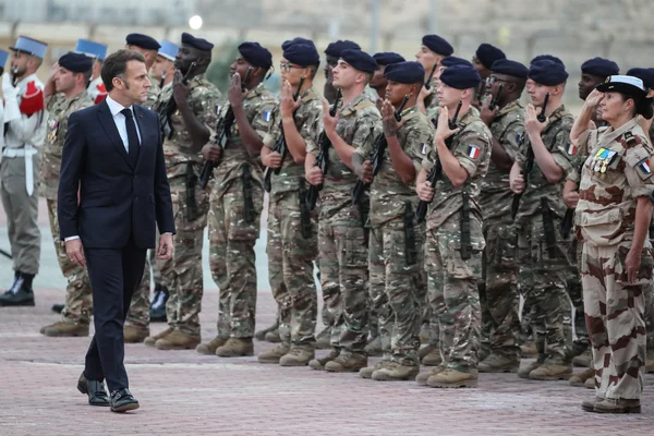 Cérémonie militaire officielle avec des soldats français en tenue de camouflage.