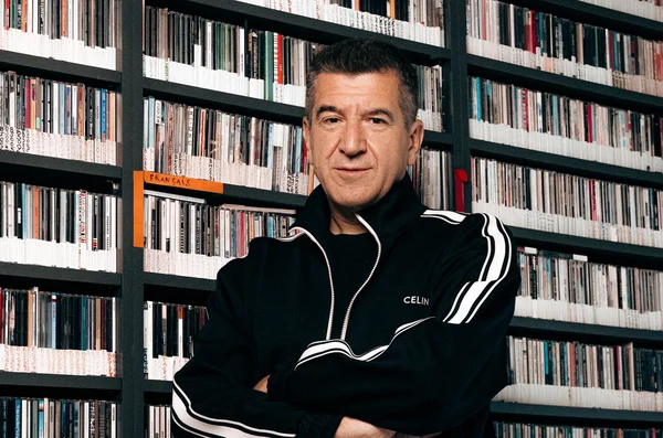 Matthieu Pigasse dans une bibliothèque musicale, veste Celine noire.