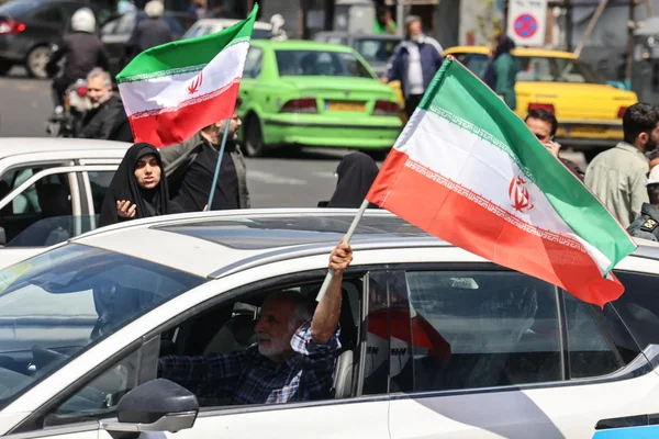 Célébration dans les rues avec des drapeaux iraniens après l'annonce du cessez-le-feu.