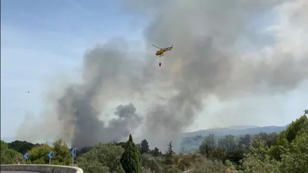 Hélicoptère bombardier d'eau déployé face à un incendie près d'habitations dans les Pyrénées-Orientales.