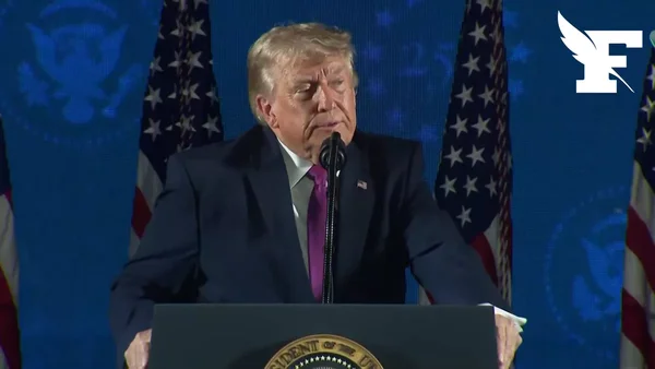 Donald Trump prenant la parole devant des drapeaux américains, avec un filigrane éditorial.