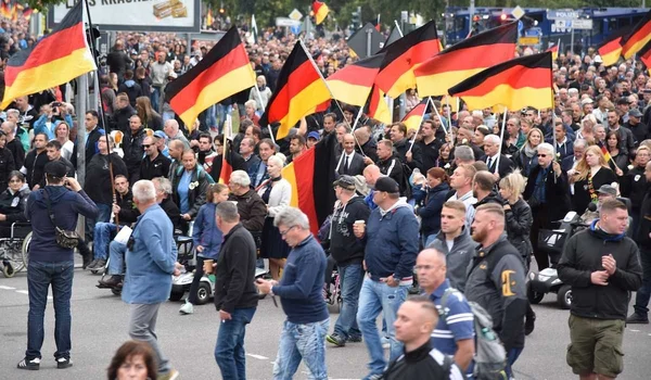 Manifestation de sympathisants d'extrême droite en Allemagne, agitant des drapeaux allemands.