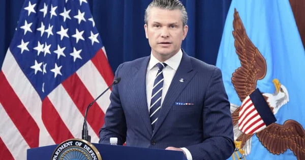 Pete Hegseth s'exprimant lors d'une conférence de presse au Pentagone, devant le sceau du département de la Défense et les drapeaux américain et de l'US Air Force.