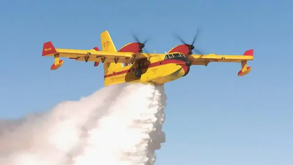 Largage par un Canadair CL-415 au-dessus d'une zone forestière.