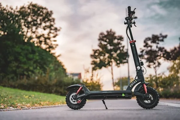 Trottinette électrique Isinwheel GT2 avec pneus tout-terrain, garée sur une piste asphaltée.