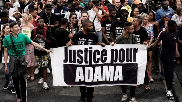 Marche de soutien à Adama Traoré, avec une banderole 'Justice pour ADAMA' en tête de cortège.