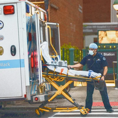 Ambulancier poussant un brancard dans une ambulance en ville.