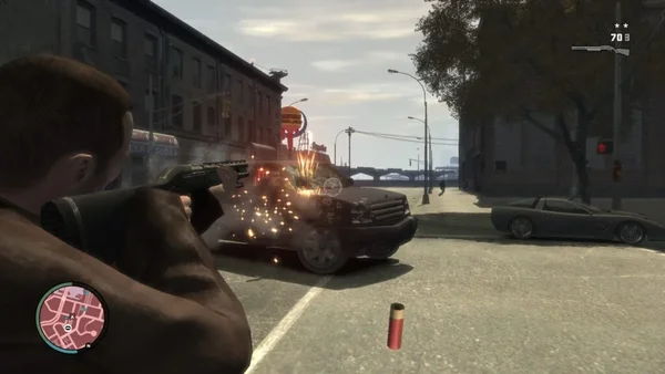 Capture d'écran authentique du gameplay de Grand Theft Auto IV (2008). L'image montre le protagoniste Niko Bellic en vue à la troisième personne, tirant avec un fusil à pompe sur une voiture dans les rues de Liberty City. L'interface utilisateur (HUD) est visible, incluant la mini-carte et l'indicateur de police, confirmant qu'il s'agit bien d'une séquence de jeu réelle.