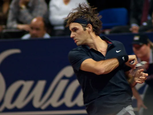 Roger Federer preparing to hit a forehand during a match.