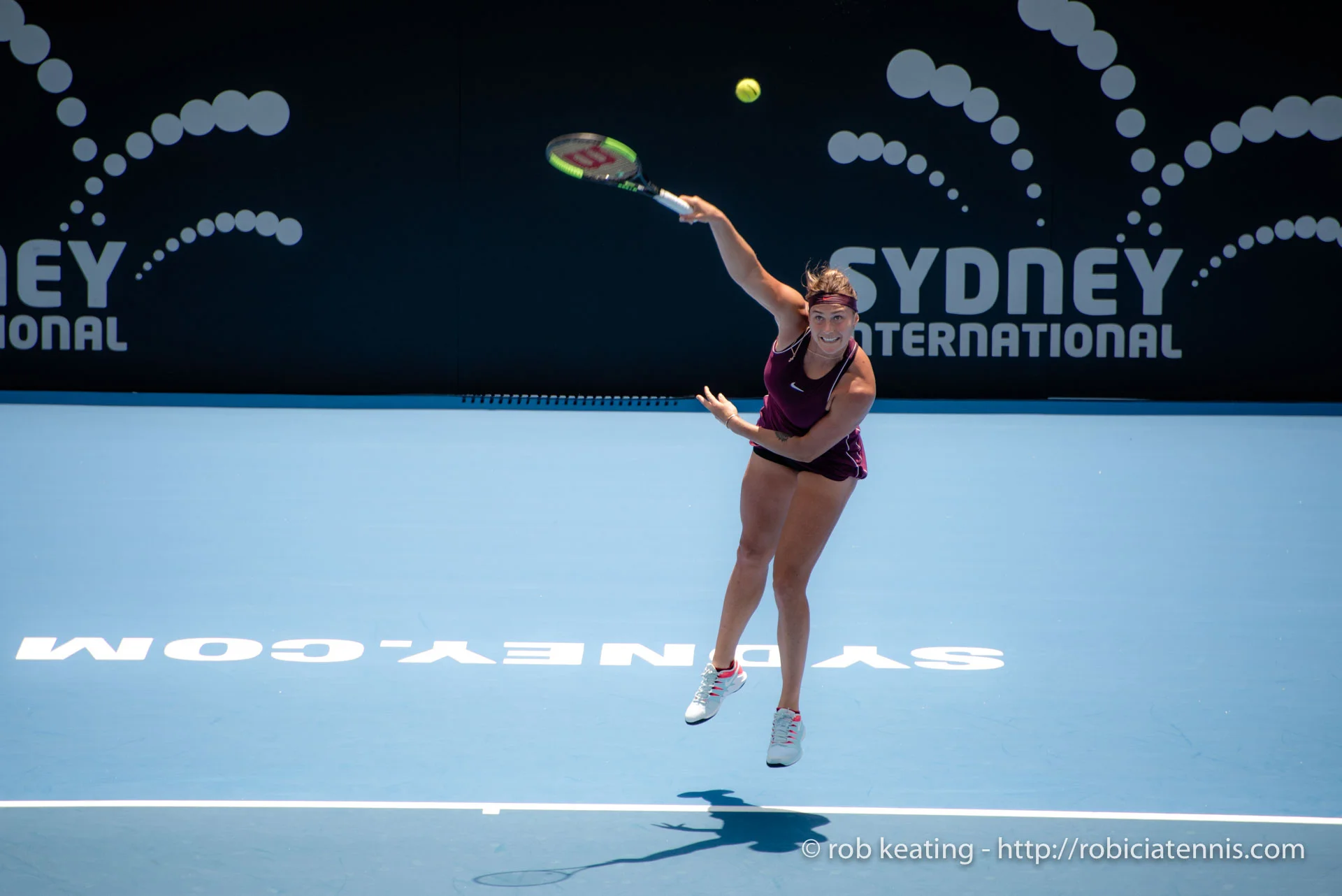 Aryna Sabalenka hitting a powerful serve during a tennis match.