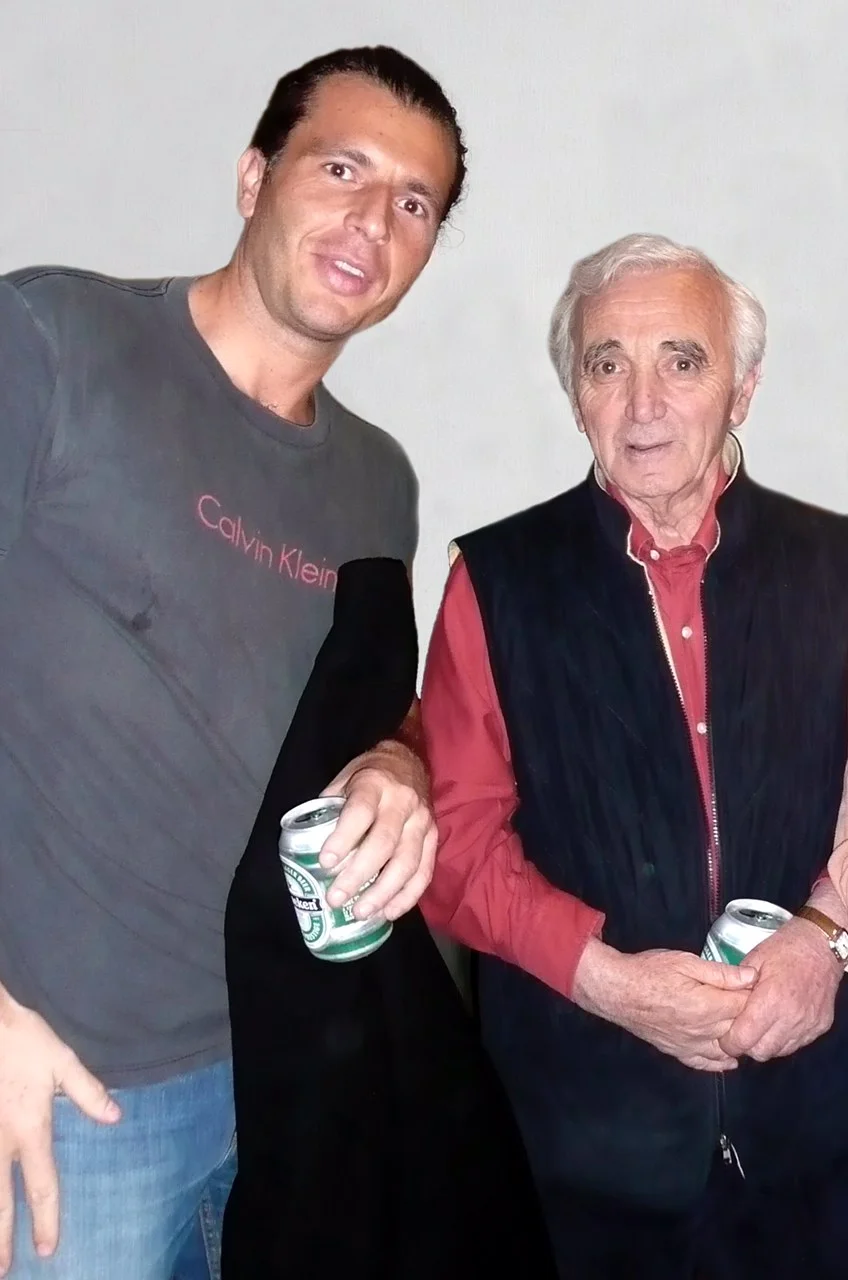 Charles Aznavour smiling with Franck Nazikian at an event